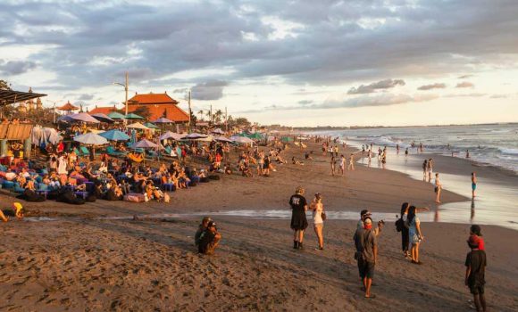 BALI, INDONESIA - FEBRUARY 18, 2017: A crowd of tourists and backpackers enjoy the sunset in a beach bar in Canggu beach, just north of Kuta and Seminyak in Bali, Indonesia